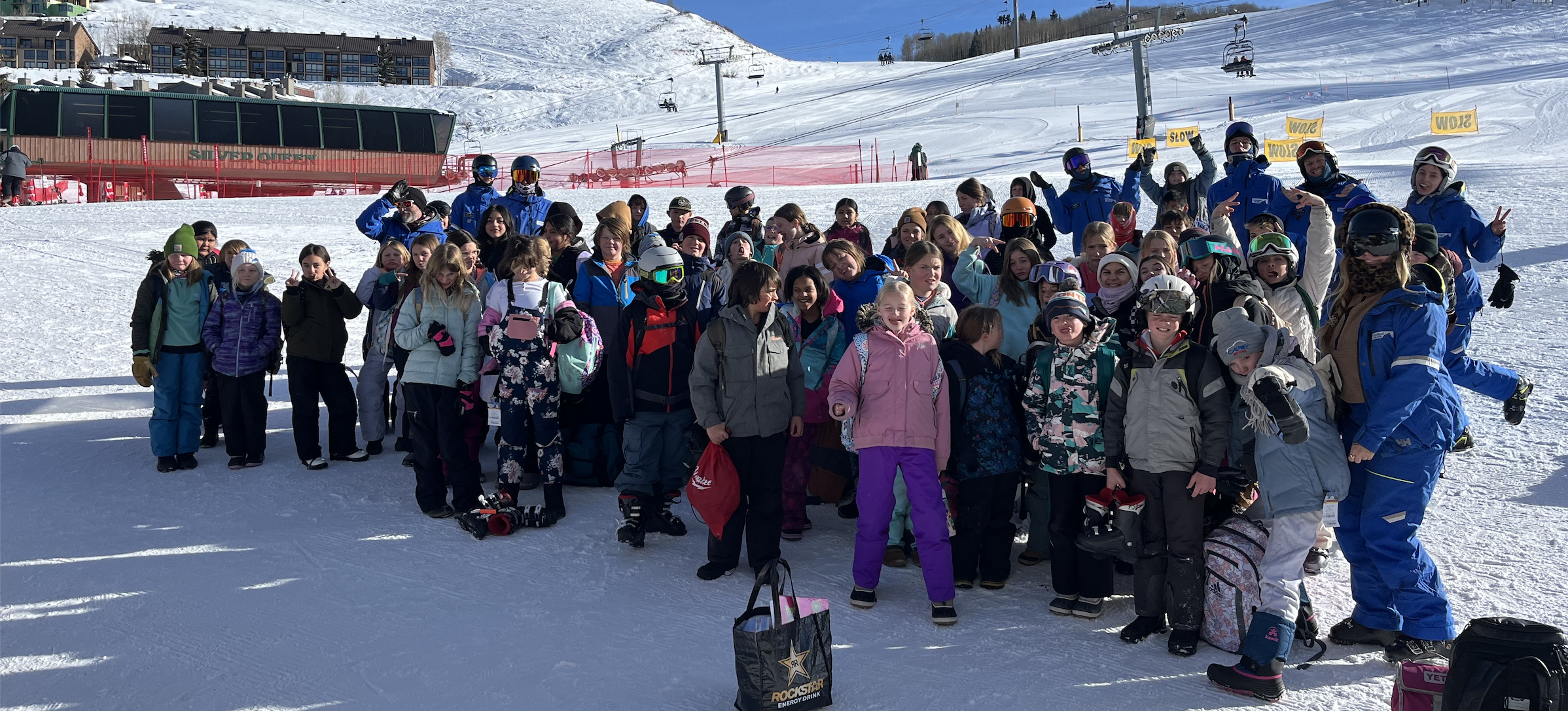 Student participants, Vail instructors and community school staff smile for a group picture at the base of CBMR.
