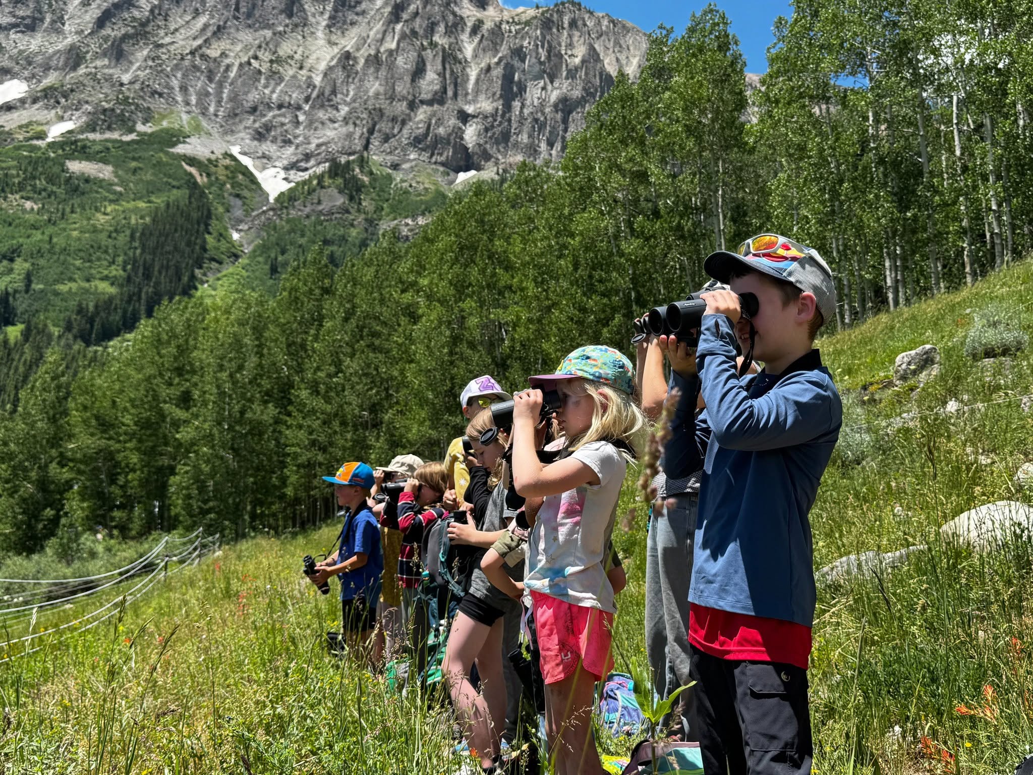 Children peer out binoculars.